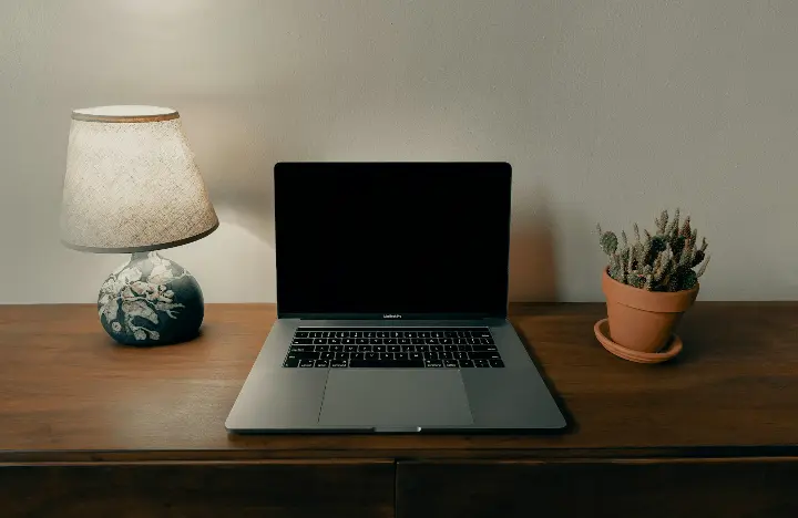 macbook pro sur une table en bois marron